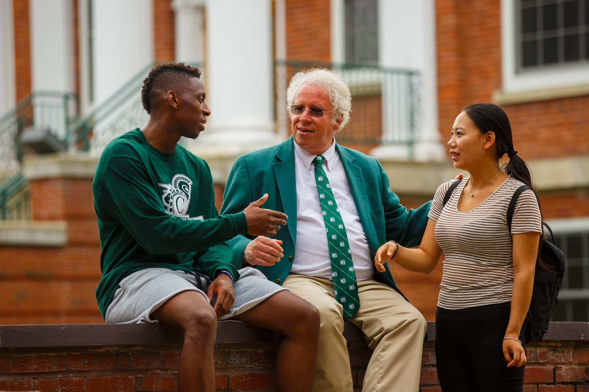 Dave Wolk talking with two students on the Castleton campus.